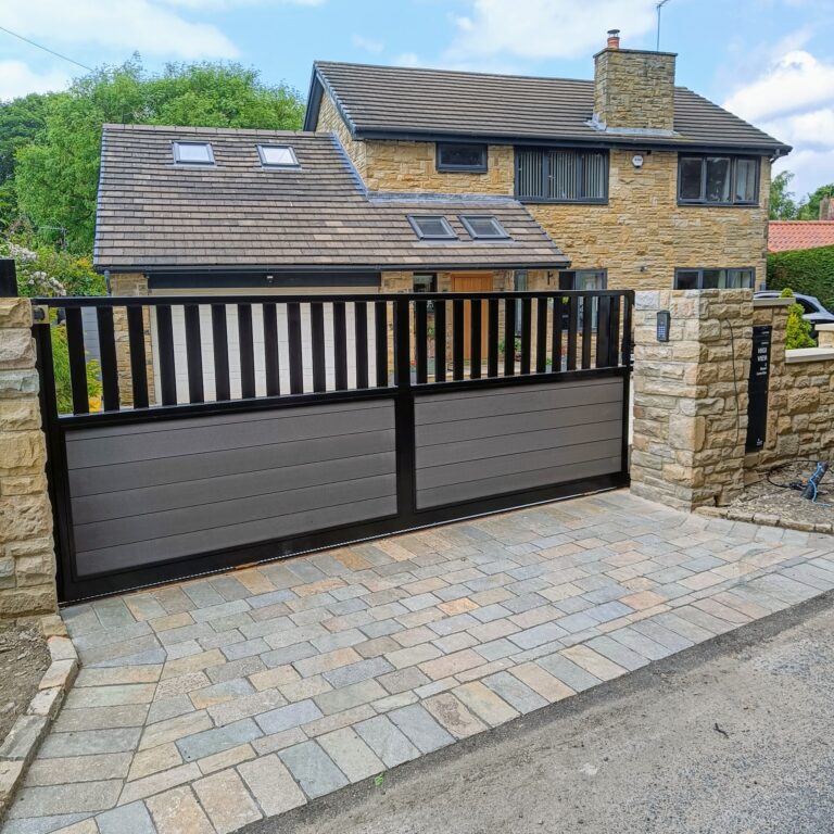 Modern driveway gate with black frame and composite panels